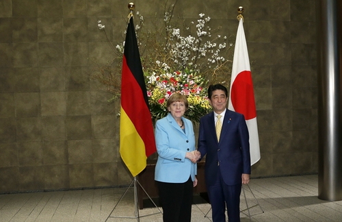 3月9日，在日本東京首相官邸，日本首相安倍晉三（右）歡迎到訪的德國總理默克爾。新華社發