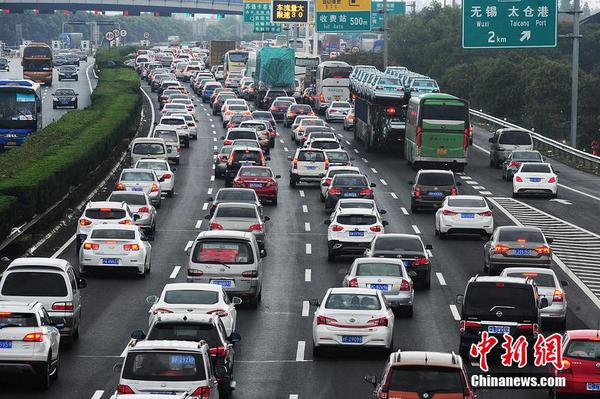 10月1日，江蘇蘇州，國慶長假高速公路免費通行第一天，沿江高速江蘇省太倉主線收費站附近出現數百米的車流長龍，從上海方向駛出的大量車輛緩慢通行經過沿江高速江蘇太倉段。計海新 攝 圖片來源 CFP視覺中國