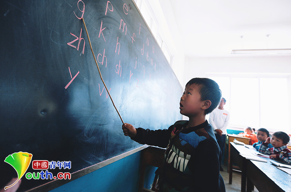 　　6歲的楊嚴國熟練地讀著黑板上的拼音字母。