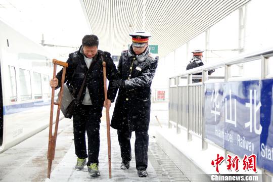 圖為鐵路工作人員幫助旅客進站。　秦姝　攝