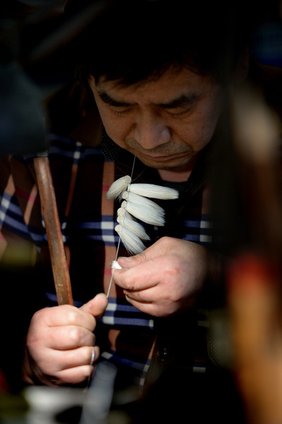 一位師傅在進(jìn)行捆頭工序的制作。