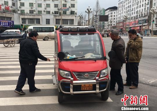 營(yíng)山城區(qū)電動(dòng)四輪車司機(jī)正在討論車輛的車況。　劉忠俊 攝