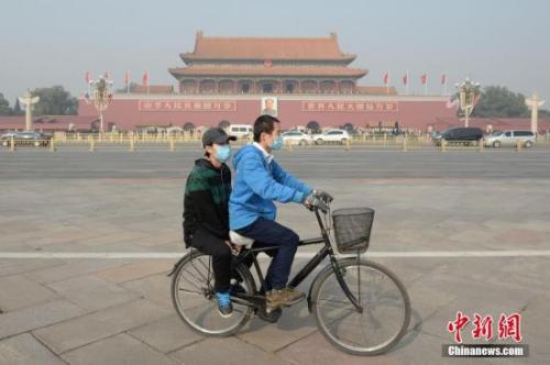 資料圖：一對青年佩戴口罩騎車經過北京天安門廣場。 <a target='_blank' href='http://www.chinanews.com/'>中新社</a>記者 崔楠 攝