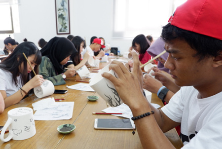 印度尼西亞學生正在繪制青花瓷茶杯圖案。(華僑大學華文學院供圖：楊惠晶 張芬妮)