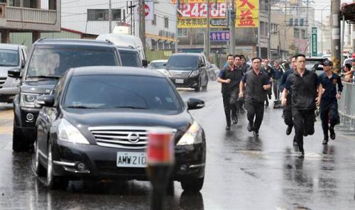 蔡英文6日南下高雄燕巢天后宮參拜，遭到軍公教人士群聚抗議，車隊抵達現(xiàn)場時維安人員跑在車隊旁戒護。(圖片來源：臺灣“中時電子報”)