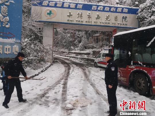 湖北十堰普降大雪，民警除雪保道路暢通 劉英 攝