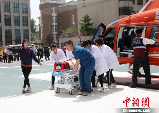 5月23日，遼寧省人民醫(yī)院完成中國(guó)東北首例異地航空醫(yī)療轉(zhuǎn)運(yùn)任務(wù)。圖為急救人員立即將患者抬上急救床。　朱明宇 攝