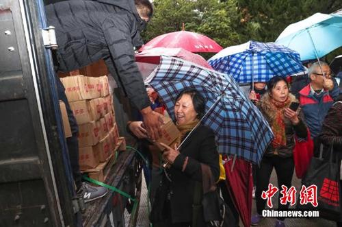 資料圖：上海百名居民在雨中排成一條長龍，領取剛到貨的秭歸臍橙。供圖