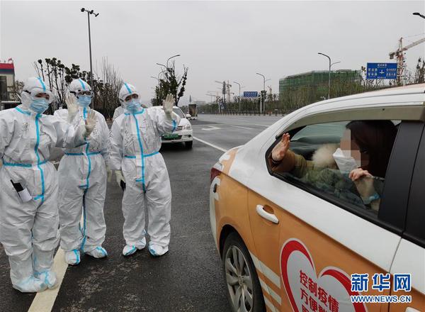 　1 武漢雷神山醫院32名新冠肺炎患者2月27日治愈出院，這是一名新冠肺炎治愈患者出院后與醫護人員告別（手機拍攝）。 新華社發（高翔 攝）