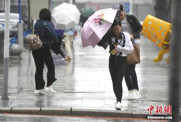 資料圖：市民頂風冒雨出行。 中新社記者 張瑤 攝